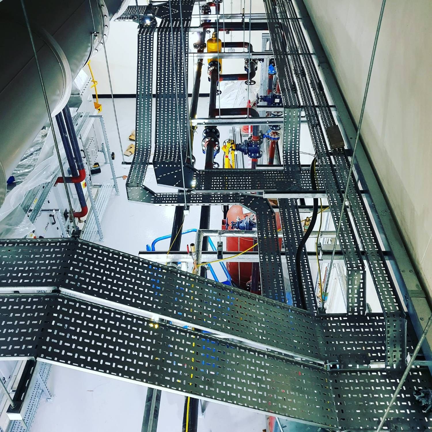 Cable tray and containment runs installed through a commercial plant room