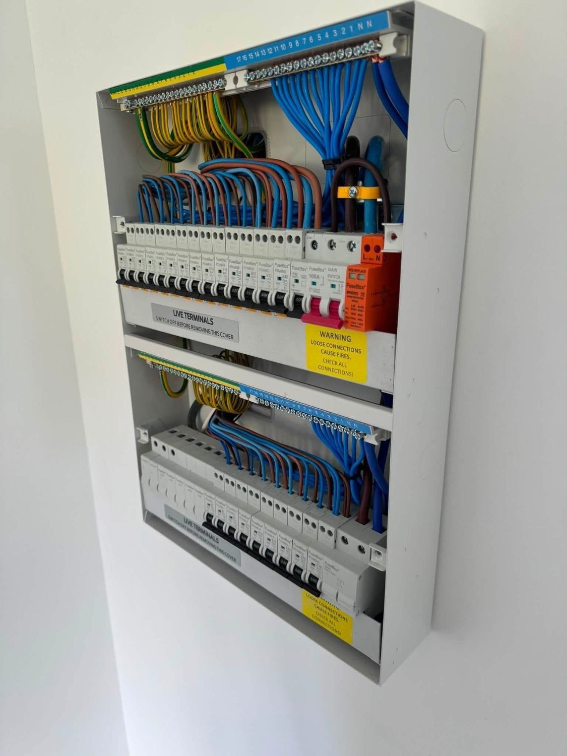 Two newly installed consumer units with dressed conductors and labelled circuits