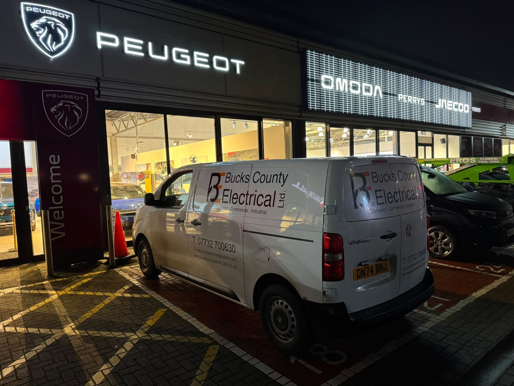 Bucks County Electrical van outside a car dealership at night